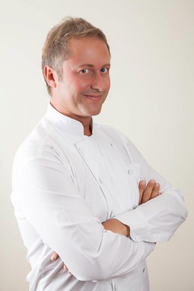 Ritratto dello chef Daniele Persegani con giacca bianca