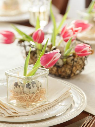 Foto di tavola imbandita con decorazioni pasquali con tulipani e Uova di quaglia